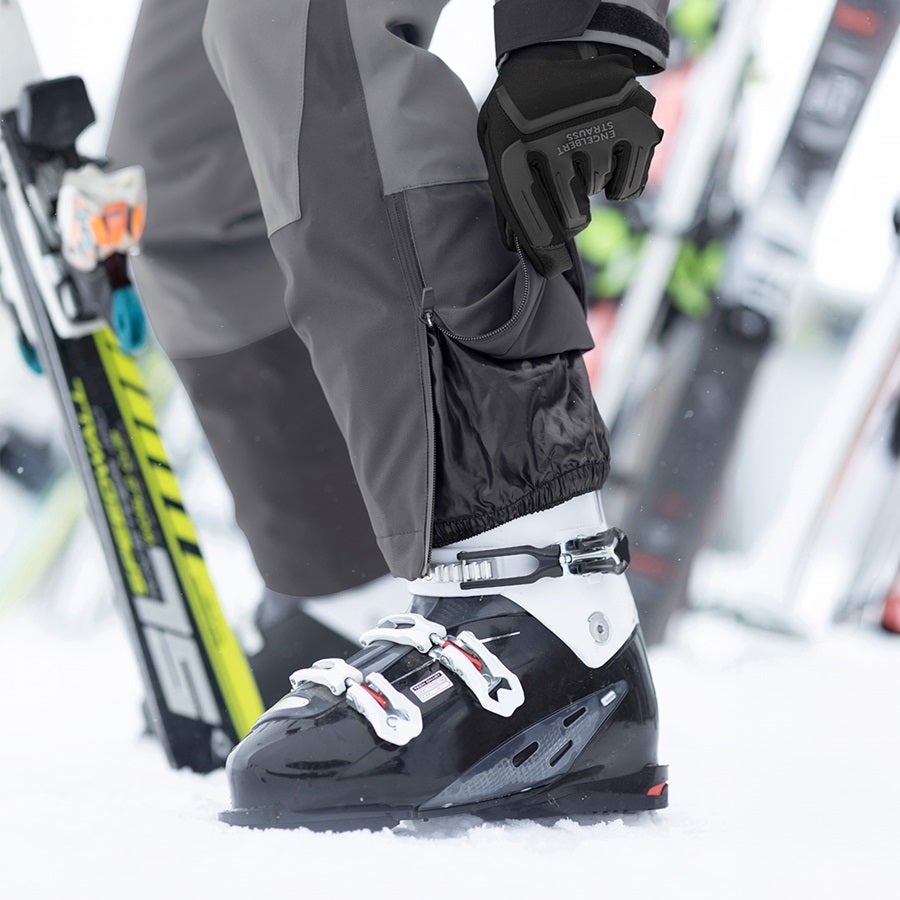 Man wearing the functional trousers e.s.trail snow in carbon grey/basalt grey with ski boots
