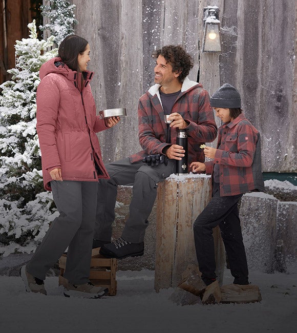 Woman, man, and boy wearing clothing from the e.s.iconic collection in a winter setting